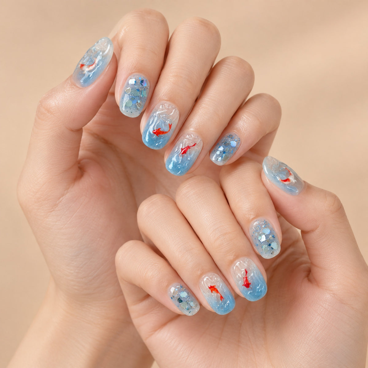 Blue koi oval press-on nails with clear water-wave details worn on both hands