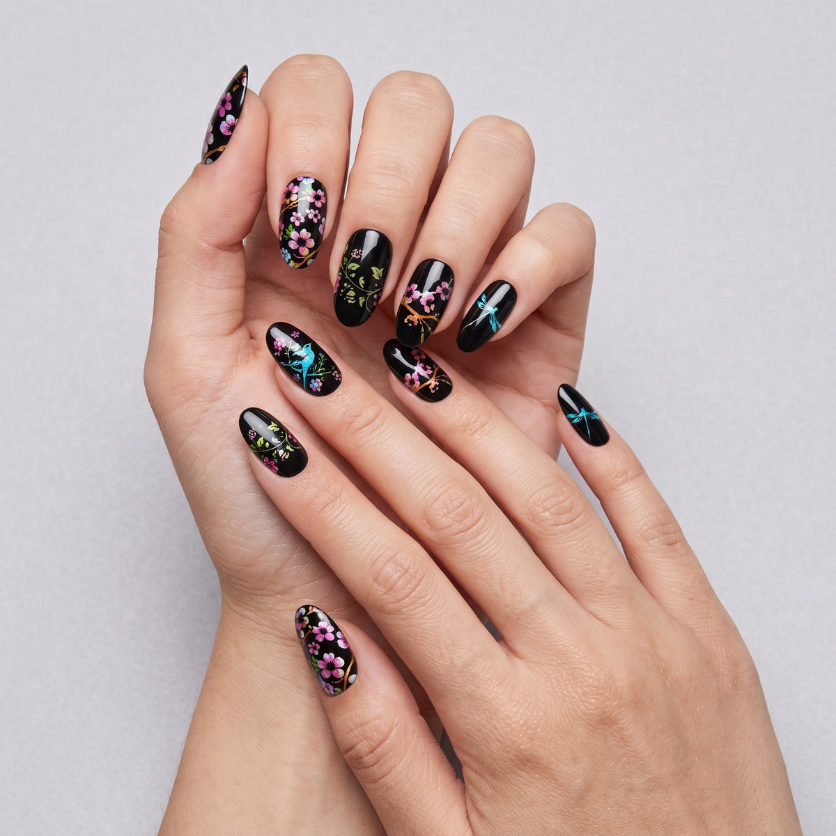 Black floral and bird oval press-on nails worn on both hands
