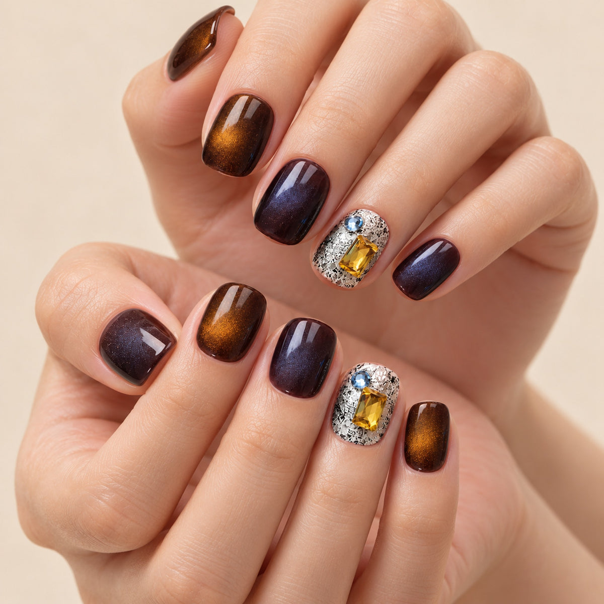 Close-up illustration of two hands wearing the brown design with silver-patterned accent nails and yellow rectangular decorations.